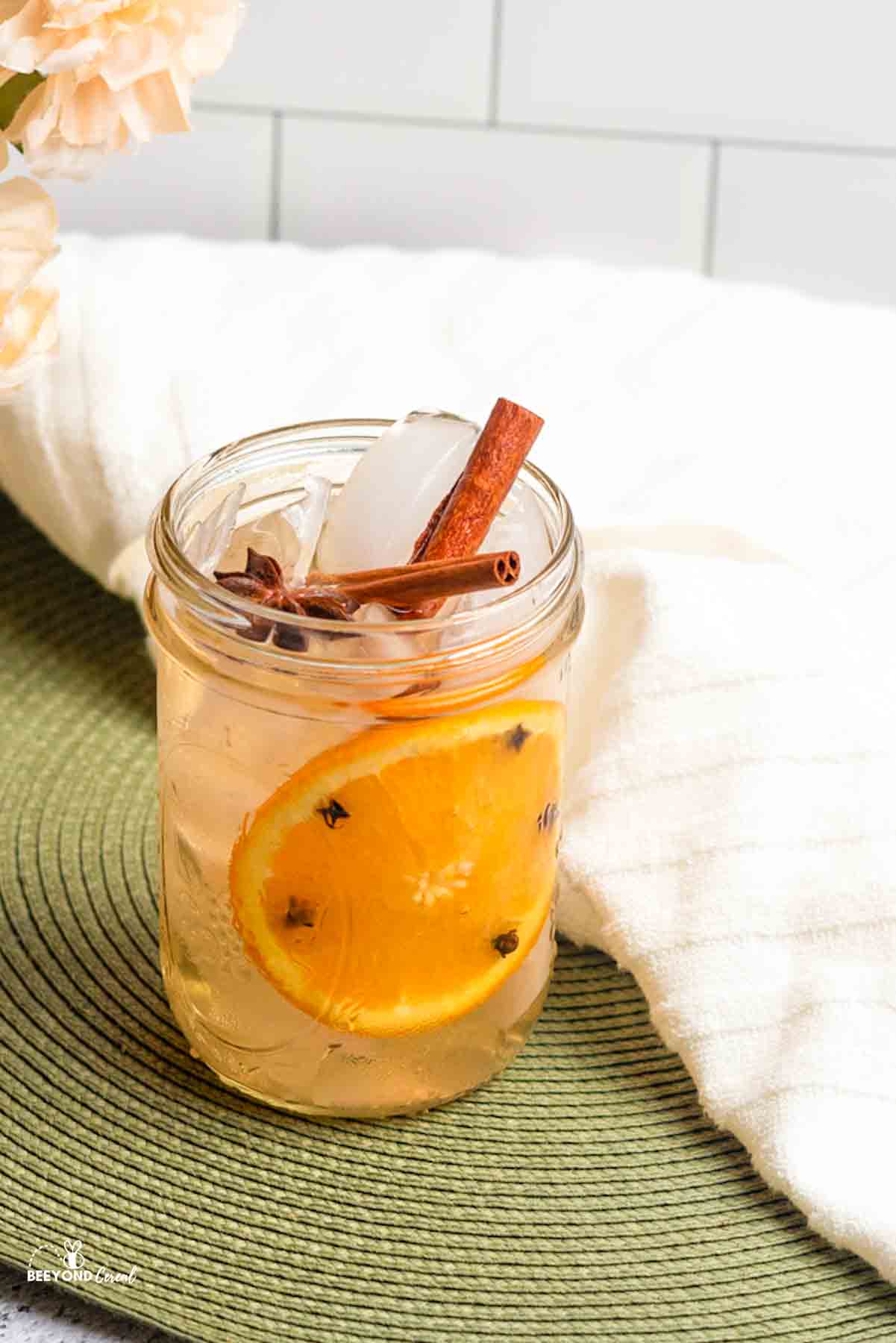a mason jar filled with orange spiced ginger ale and topped with cinnamon sticks