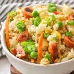 an upclose view of a bowl of hot dog fried rice with veggies