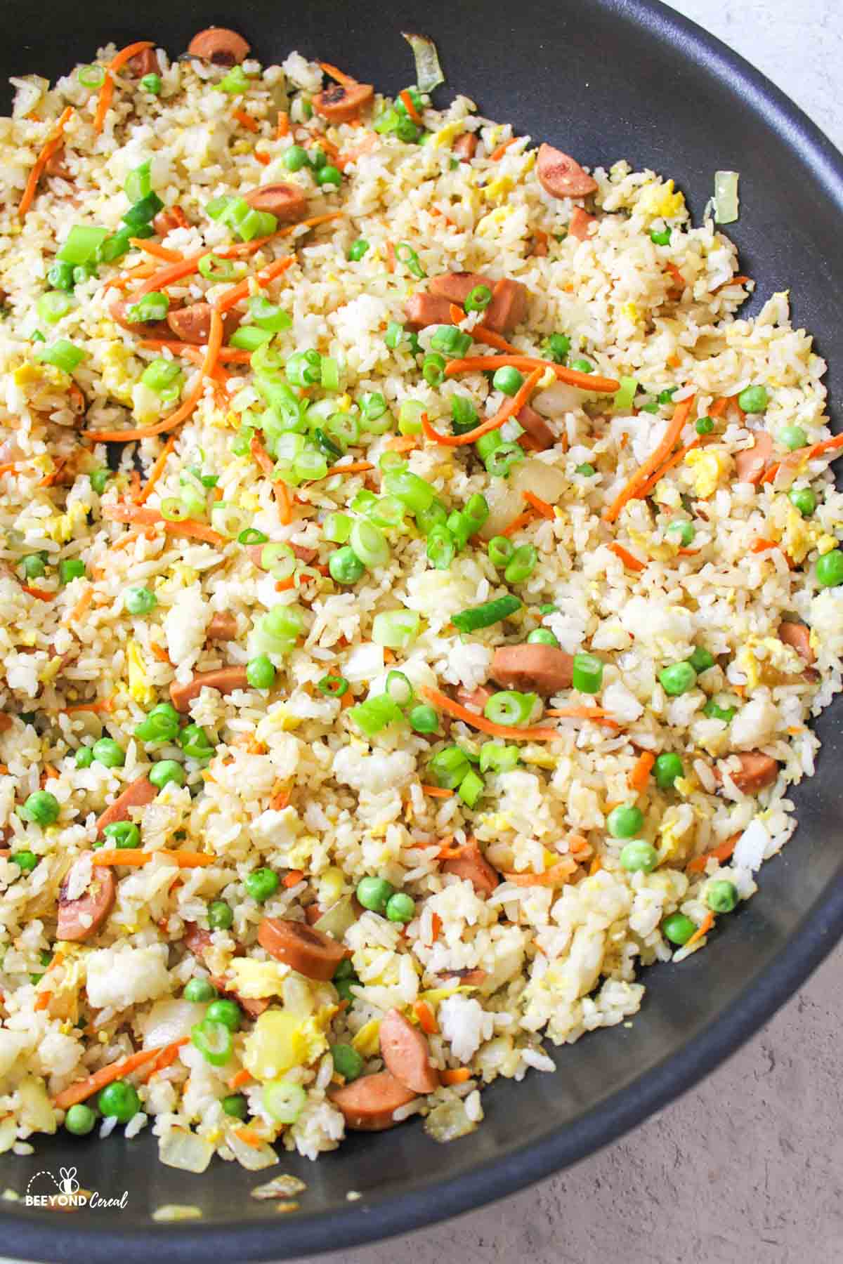 hot dog fried rice in a large black wok.