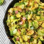 an upclose view of bacon ranch brussel sprouts in cast iron pan