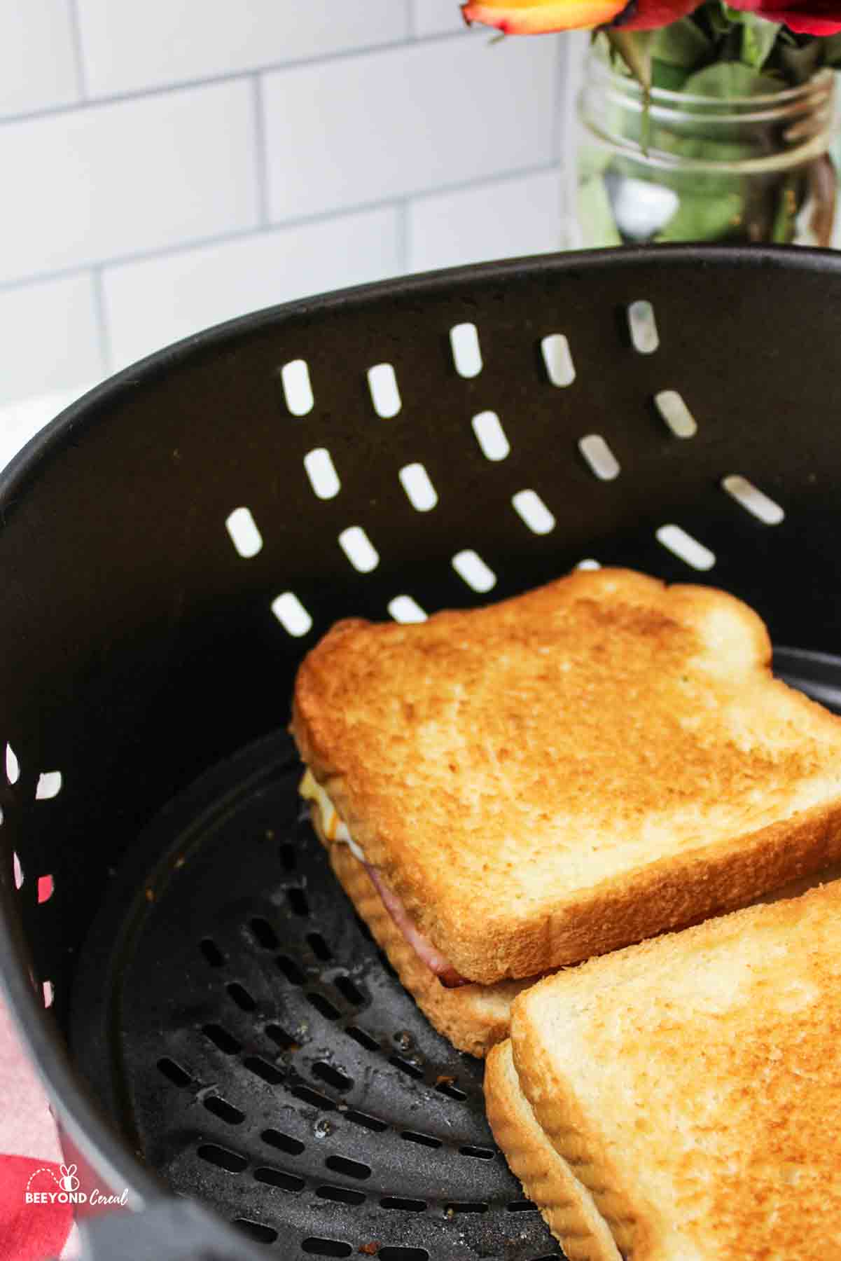 a cooked ham and cheese air fried sandwich in air fryer basket