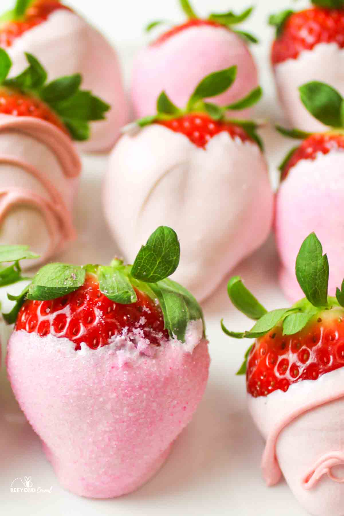 pink chocolate covered strawberries with green leaves