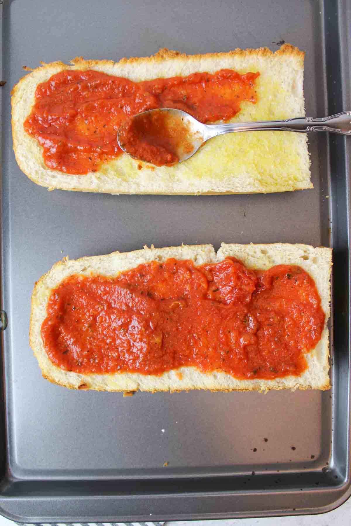 spread pizza sauce on the french bread to make pizza