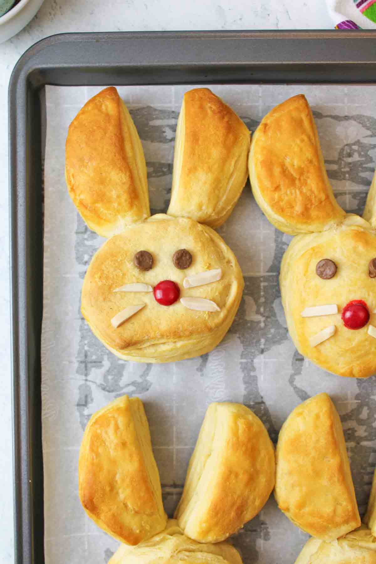 easter bunny biscuits on a parchment paper lined baking sheet.