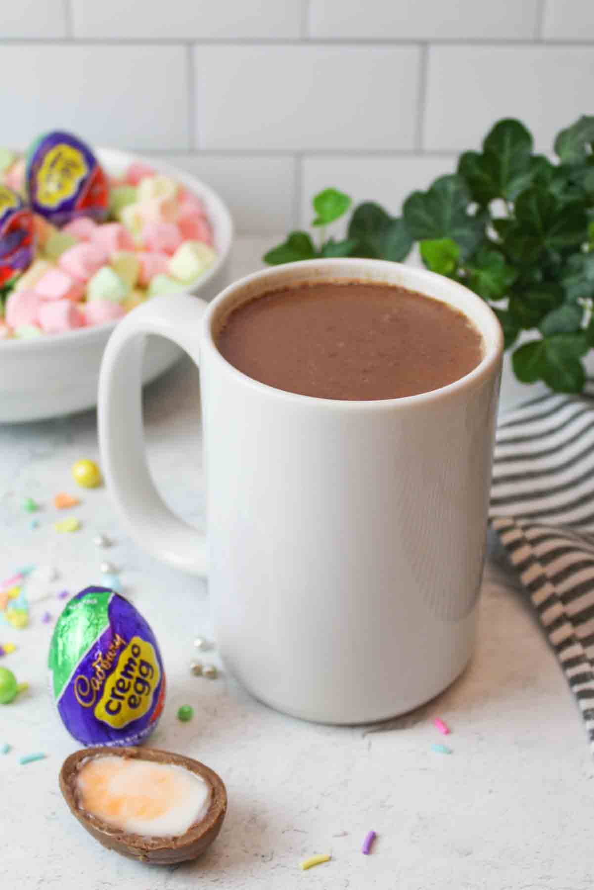 a white mug filled with cadbury creme hot chocolate.