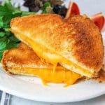 two halves of microwave grilled cheese sandwich with gooey melty cheese.