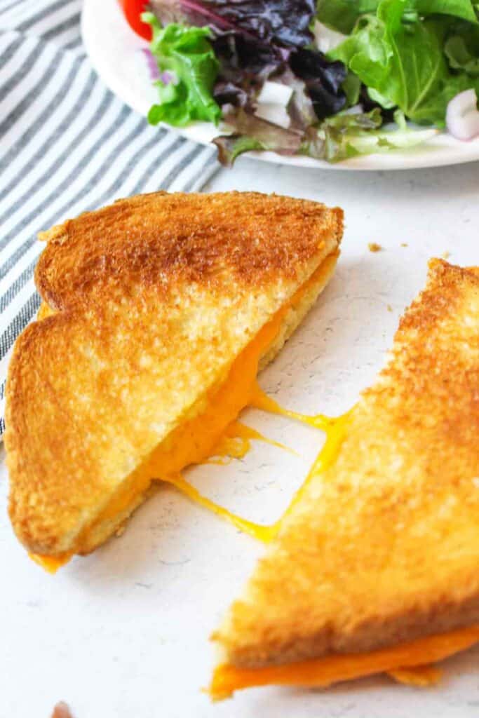 two microwaved grilled cheese halves with melted cheese in between them