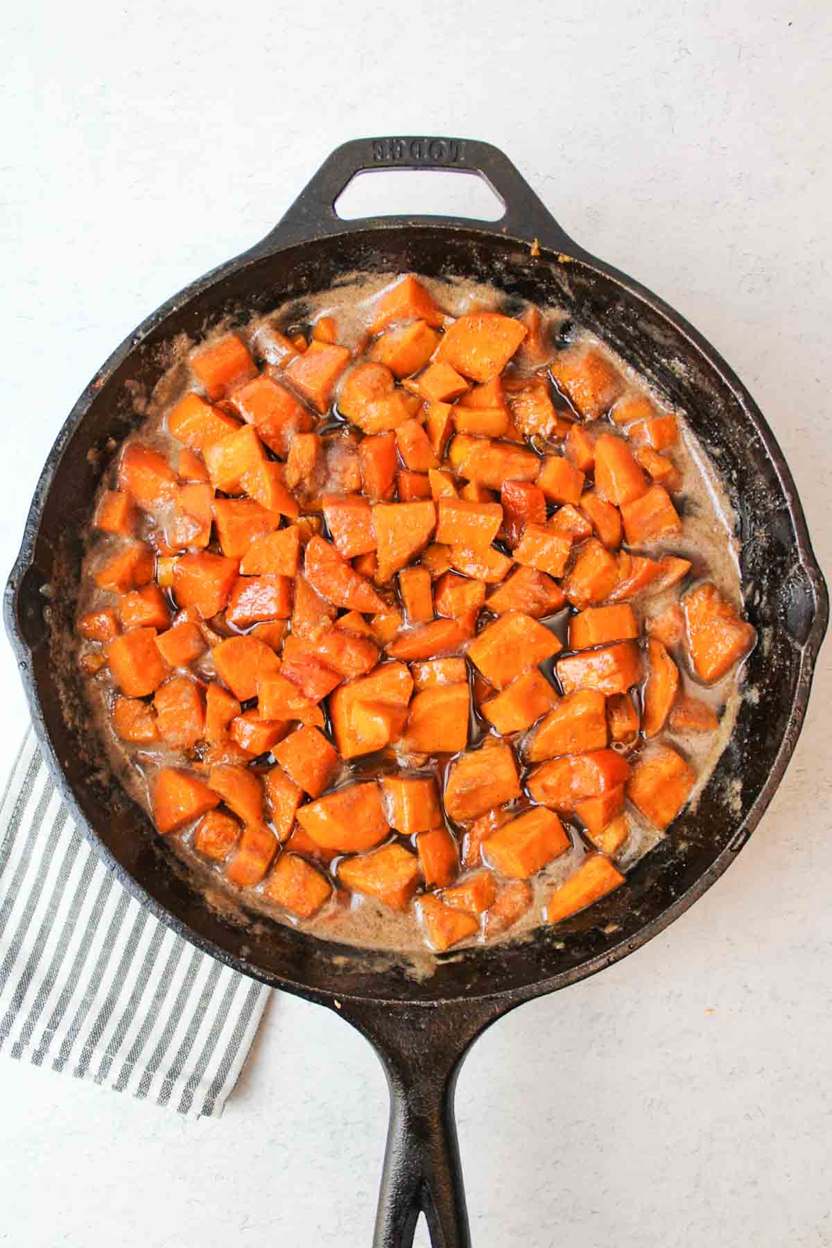 candied stove top sweet potatoes in a cast iron skillet.