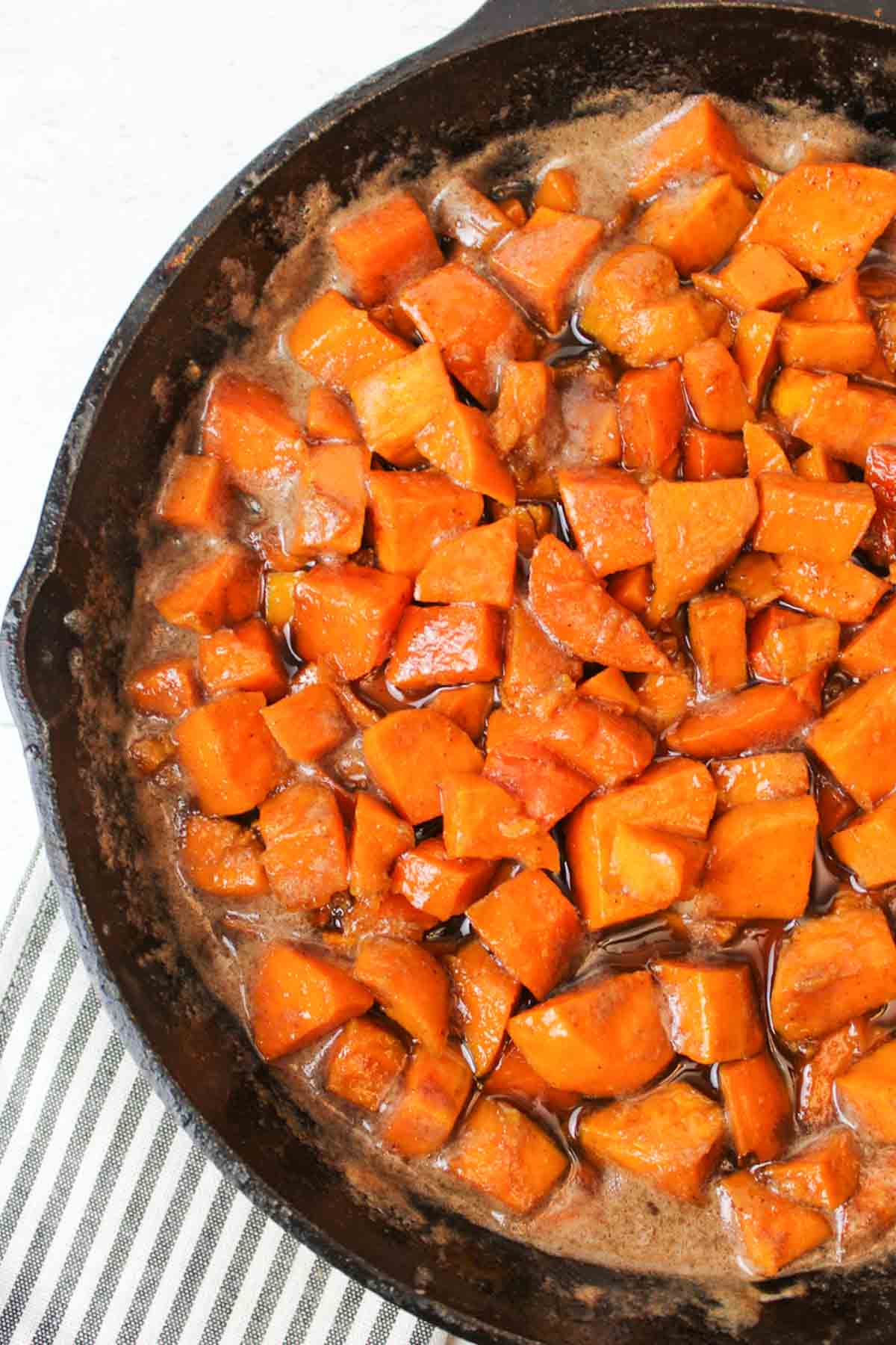 a close up of half of a pan filled with candied sweet potatoes