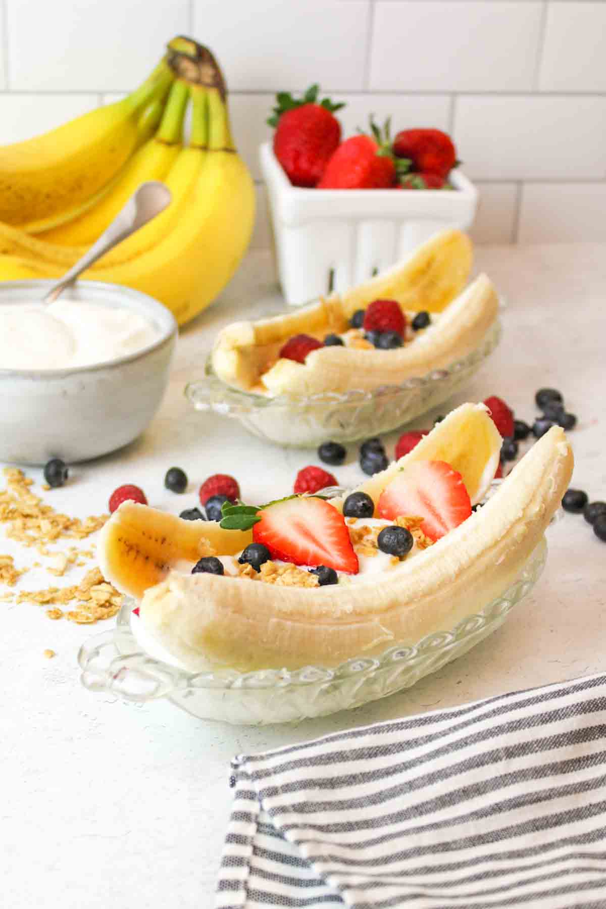 healthy banana splits with fresh berries and granola.