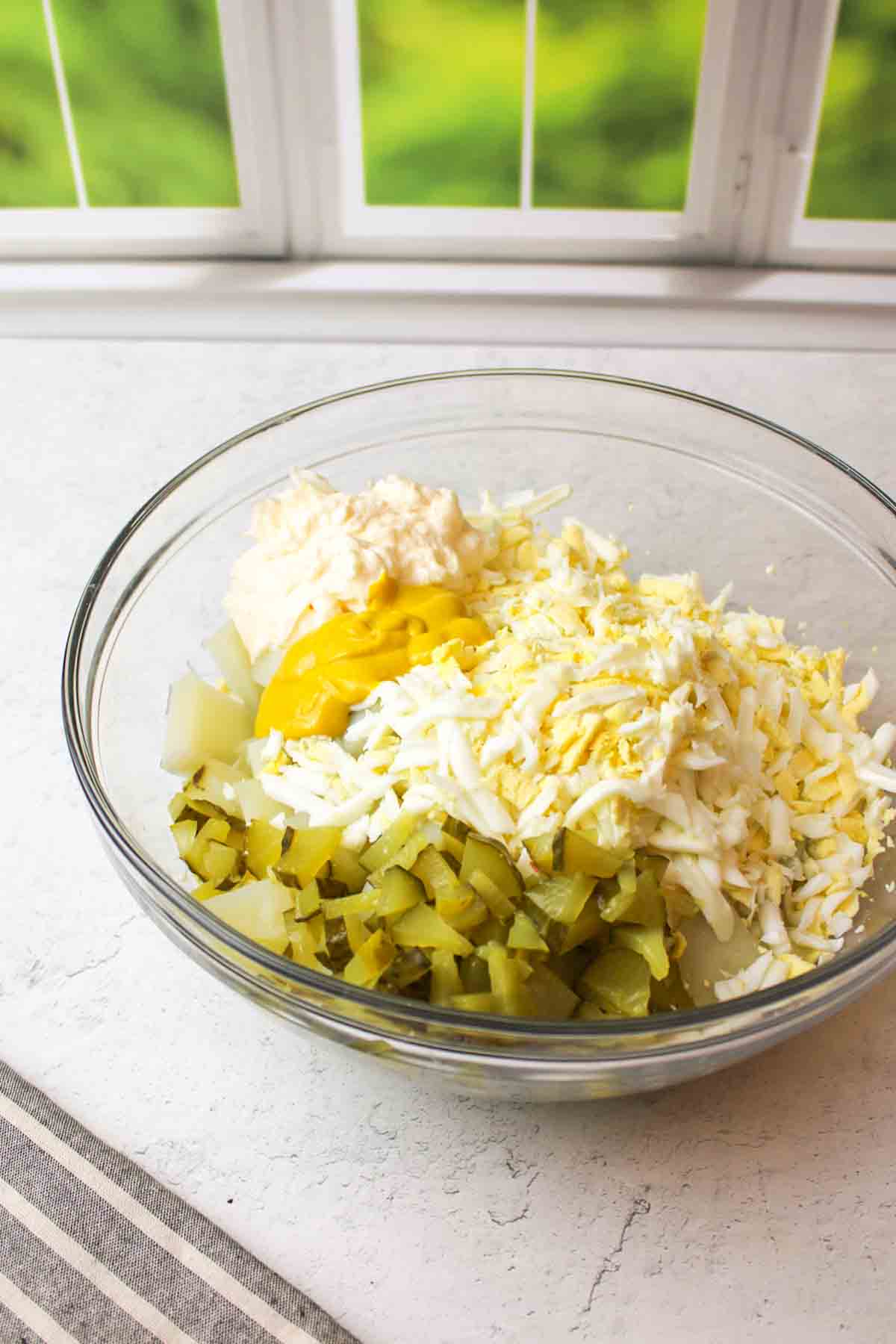 the ingredients needed to make dill pickle potato salad in a mixing bowl
