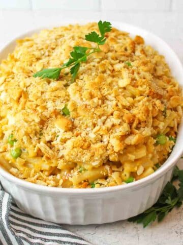 mac and cheese tuna casserole in a casserole dish with parsley on top.