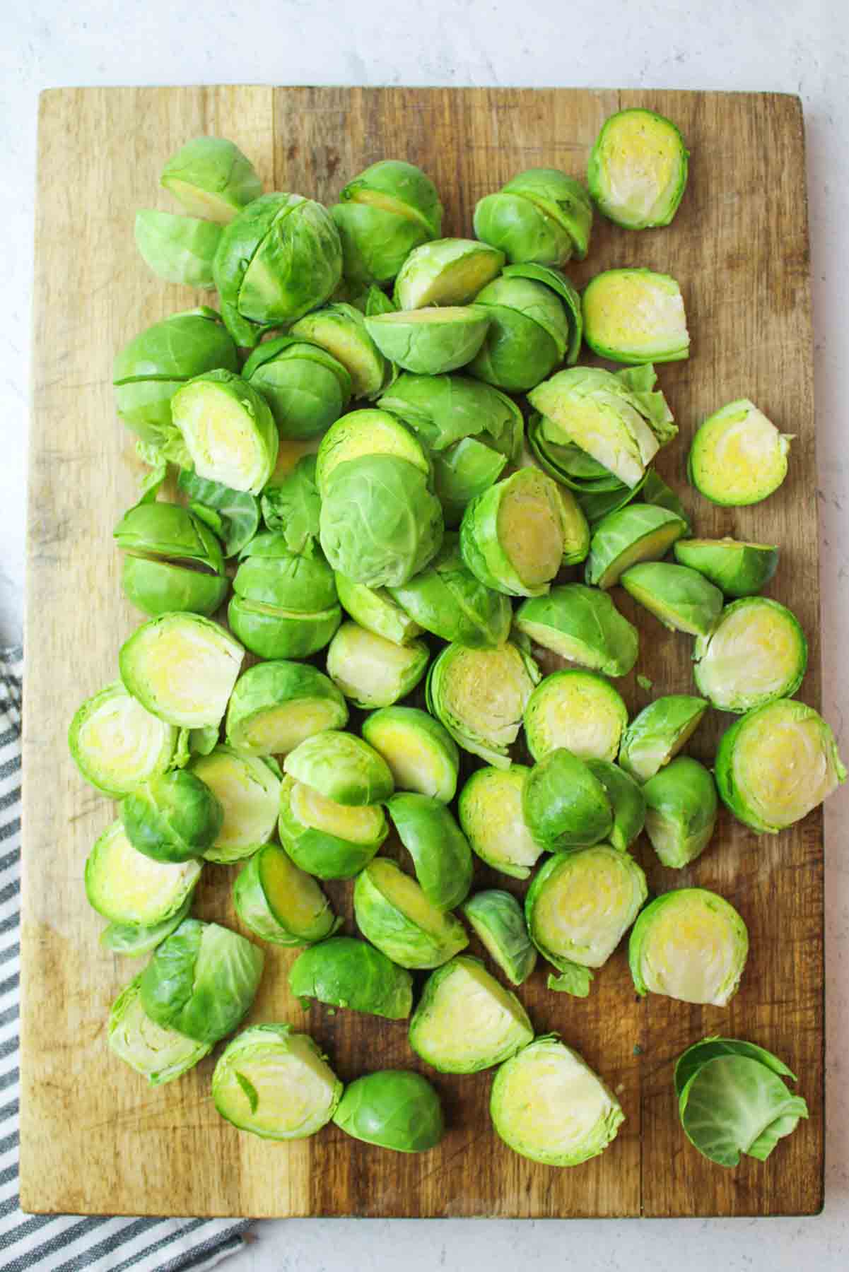 halved brussel sprouts on a wooden cutting board.