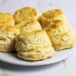 several tall biscuits on a white plate.