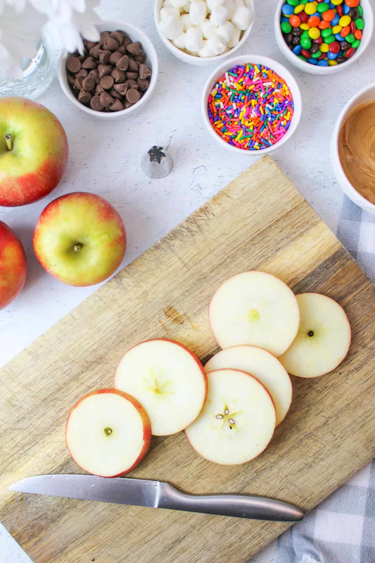 apple on a cutting board with a knife slicing it thinly