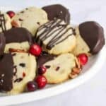 chocolate dipped cranberry shortbread cookies on an oval plate