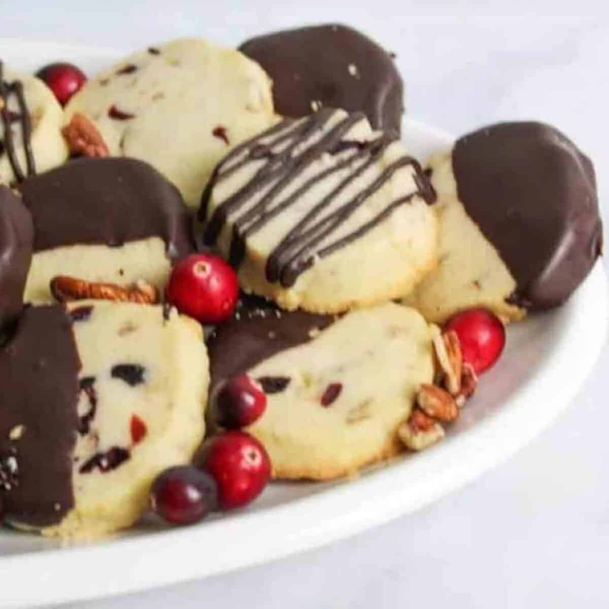 chocolate dipped cranberry shortbread cookies on an oval plate.