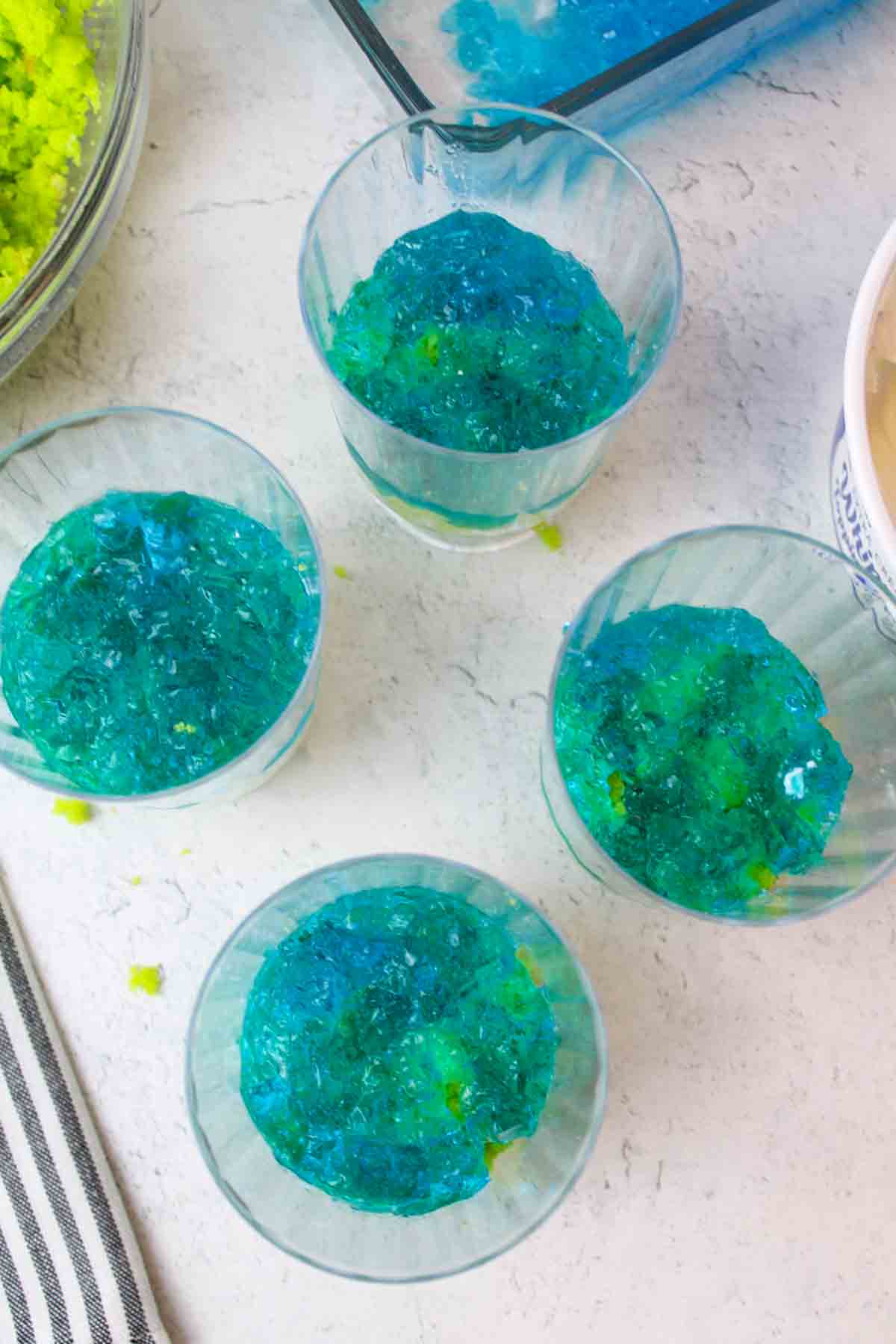 blue jello on top of green cake in clear cups