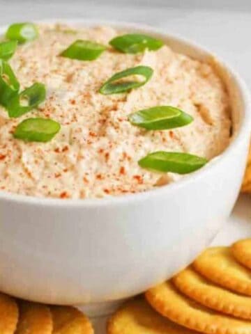 trout dip in a bowl with crackers around it.