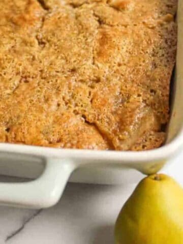 the corner of a baking dish filled with pear cobbler