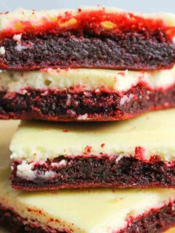 Red Velvet Cheesecake brownies stacked on top of eachother.
