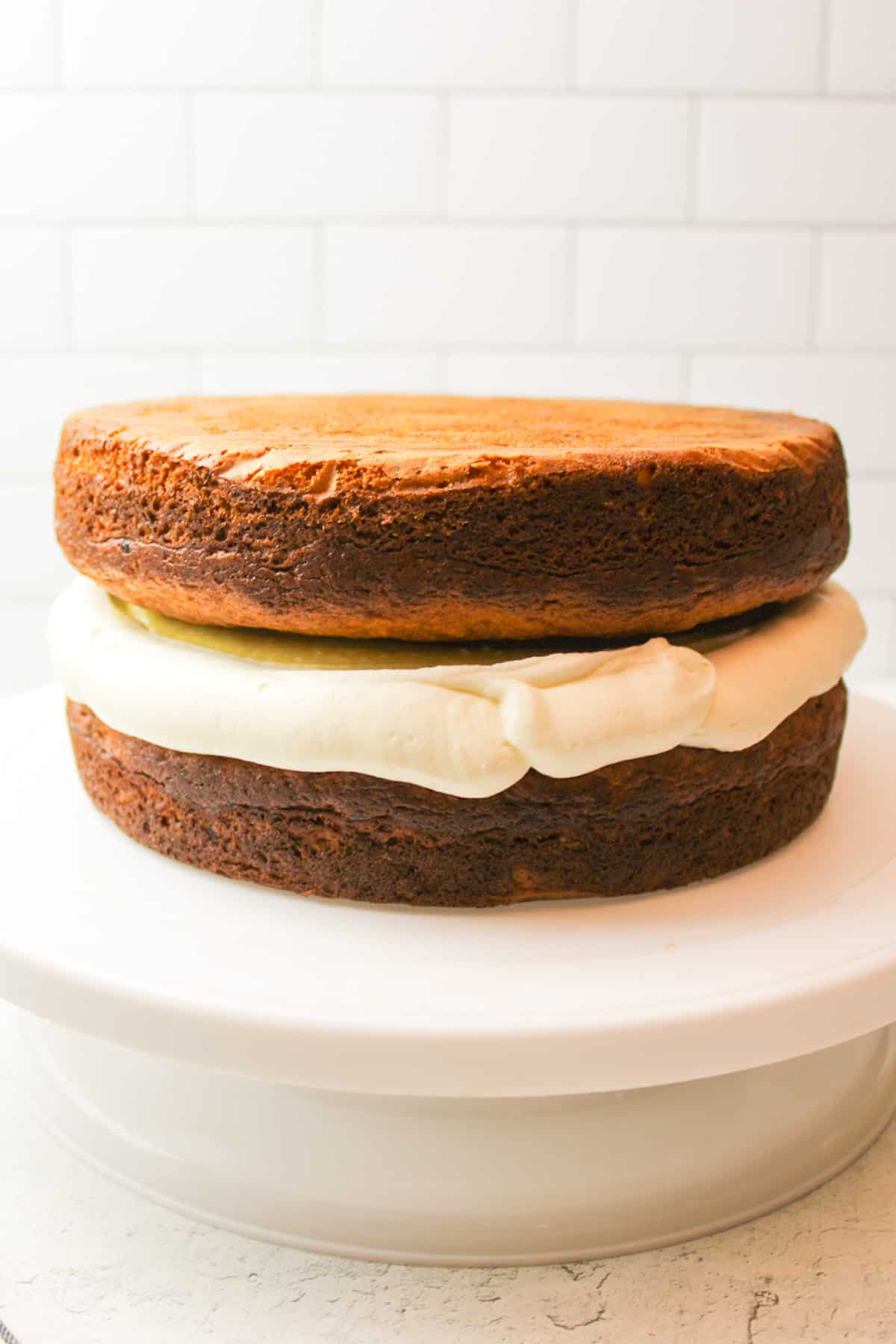 stacked banana cake with frosting around the middle