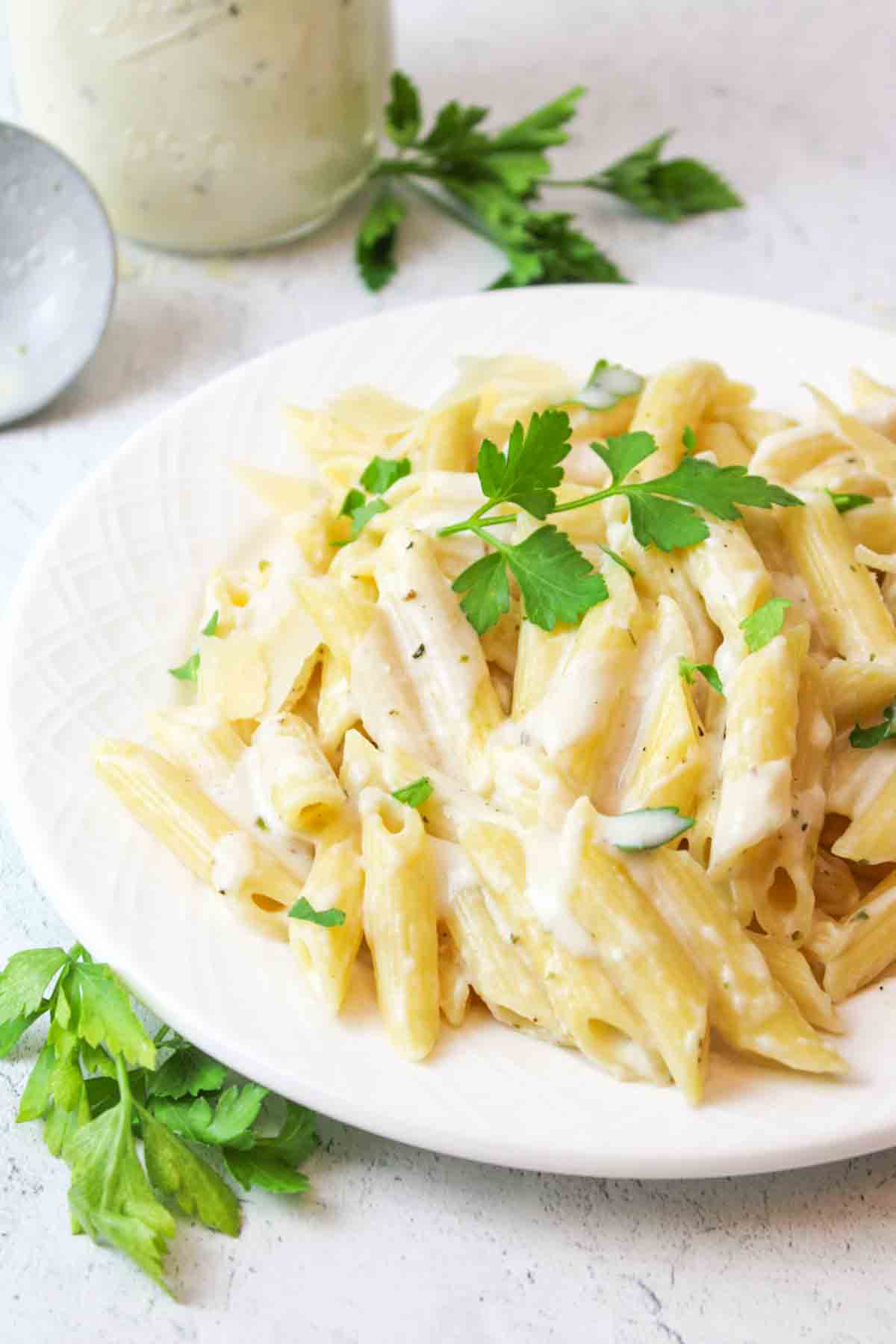 fresh parsley on a plate of cream cheese penne pasta