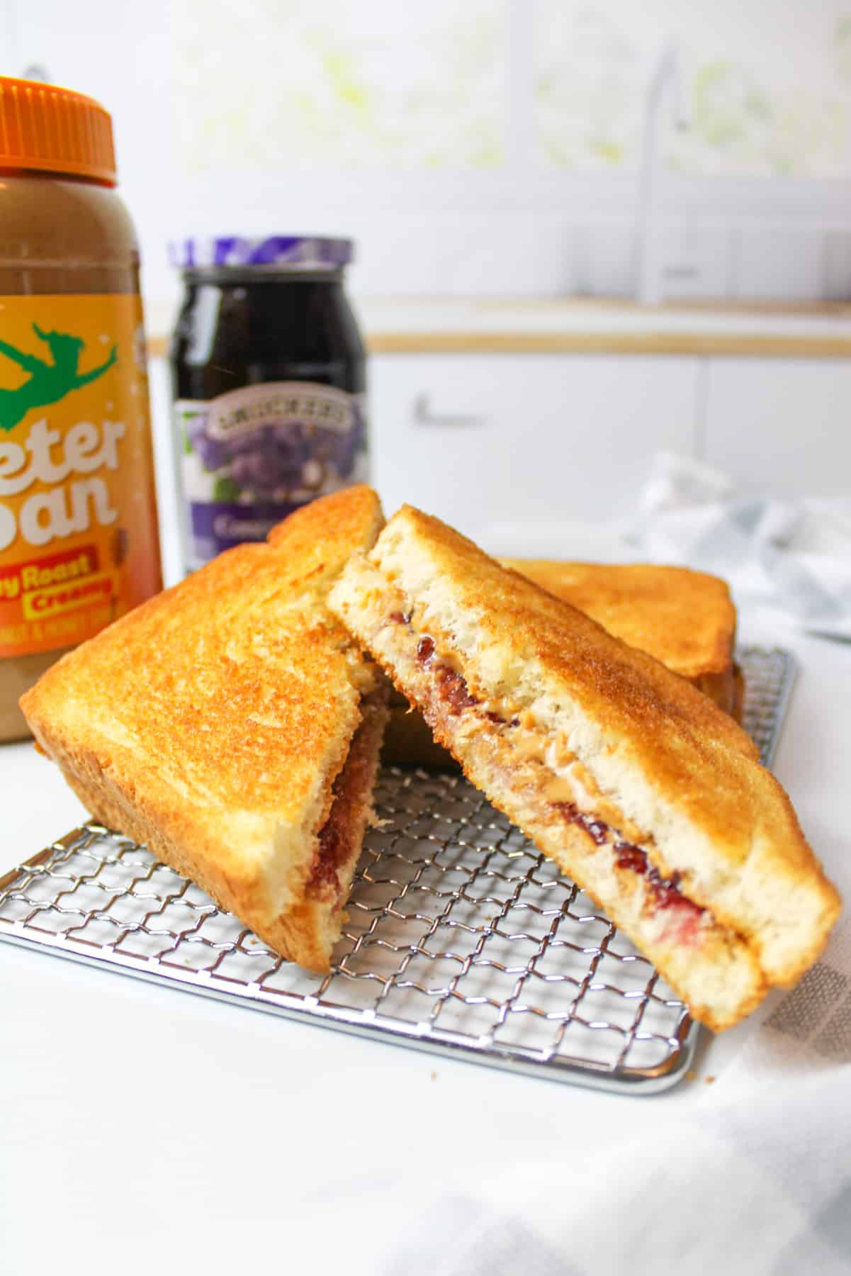 sliced and angled air fried pbj sandwich on wire rack.