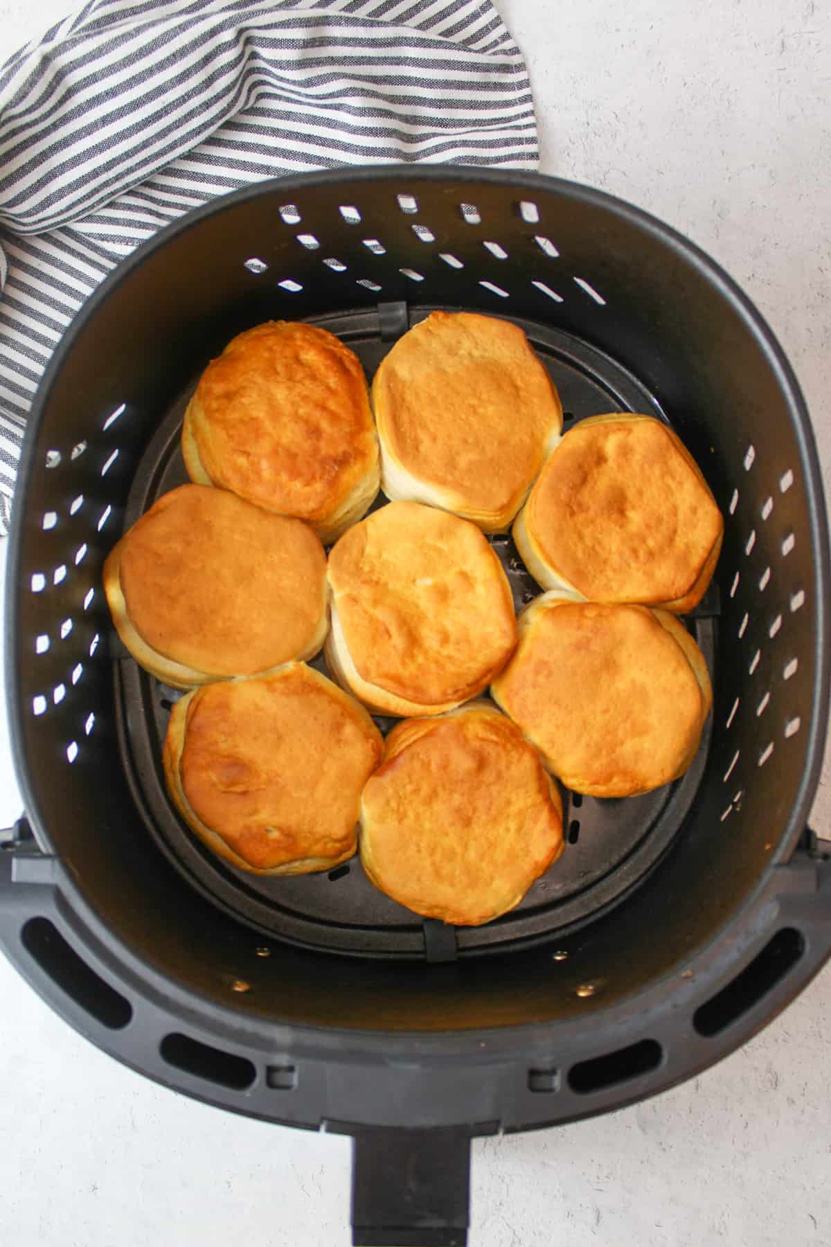 air fried canned biscuits in an air fryer basket.