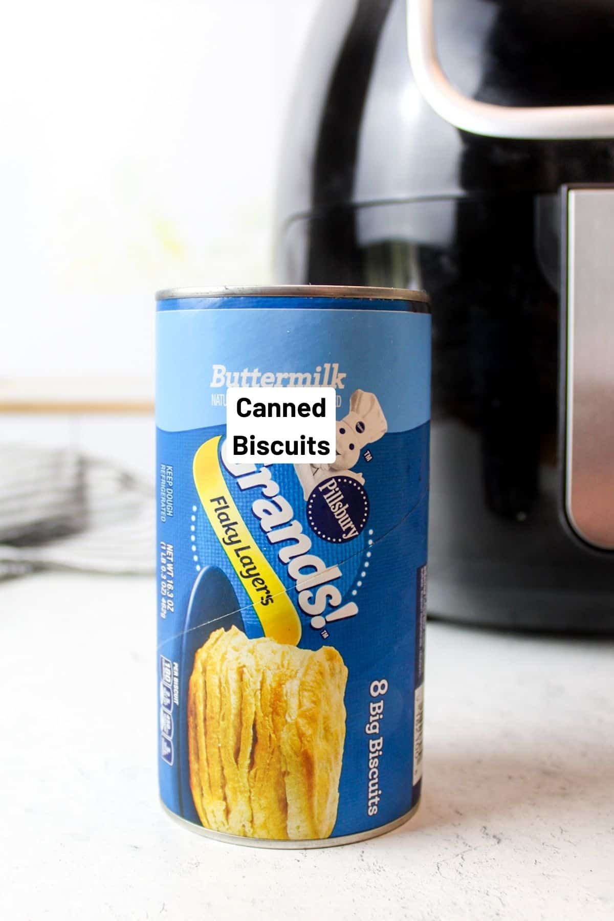 can of biscuits in front of air fryer.