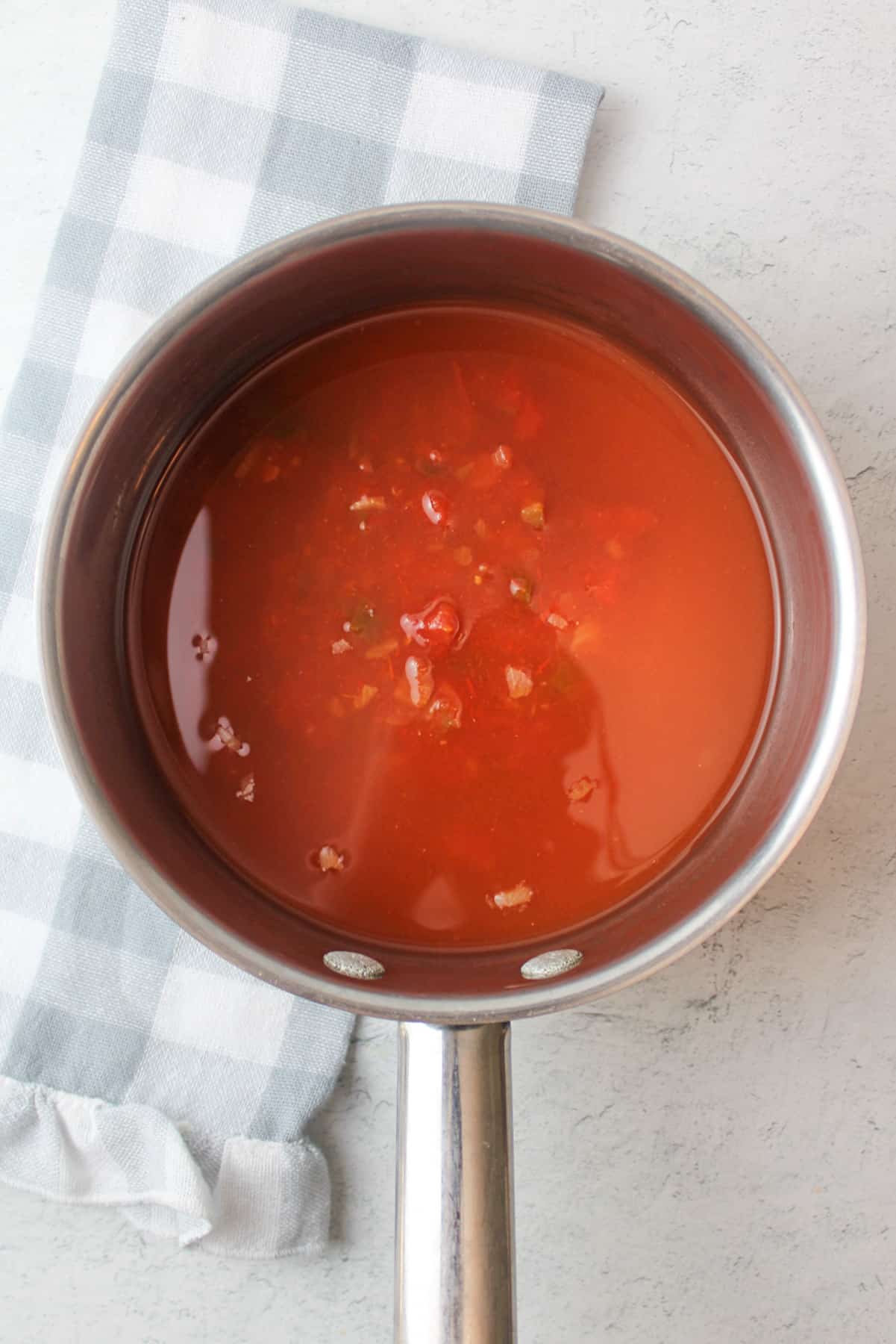 red salsa and water in a pot.