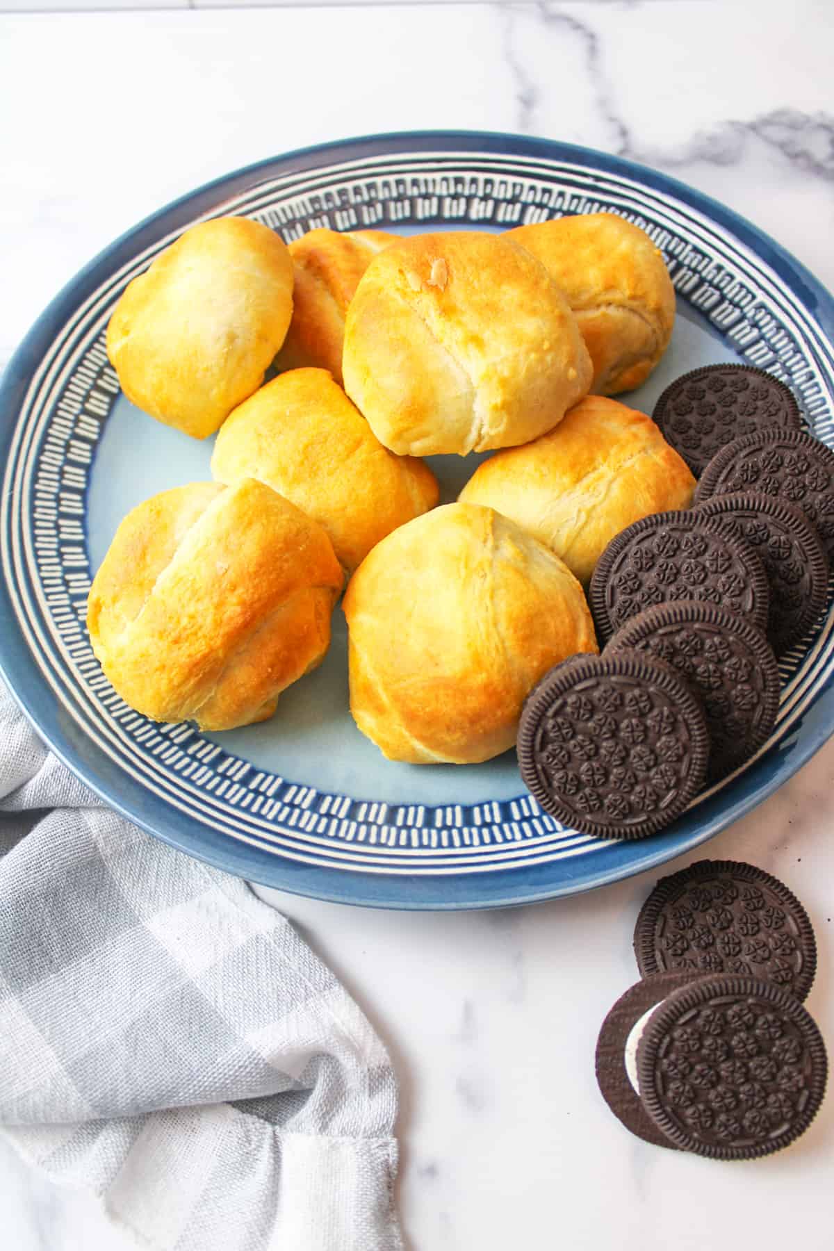 air fried crescent roll covered oreo cookies on a plate next to oreo cookies.