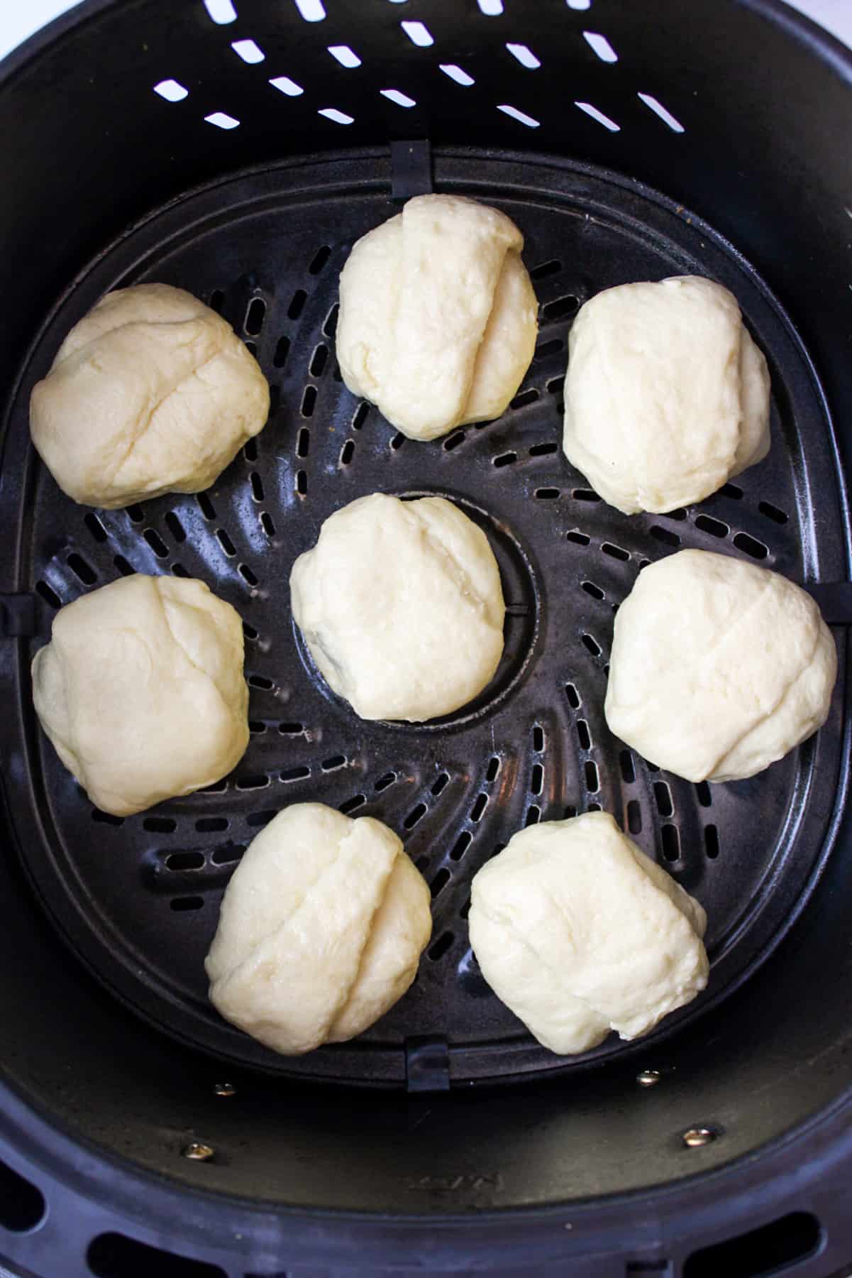 crescent roll covered oreo cookies in the basket of an air fryer.