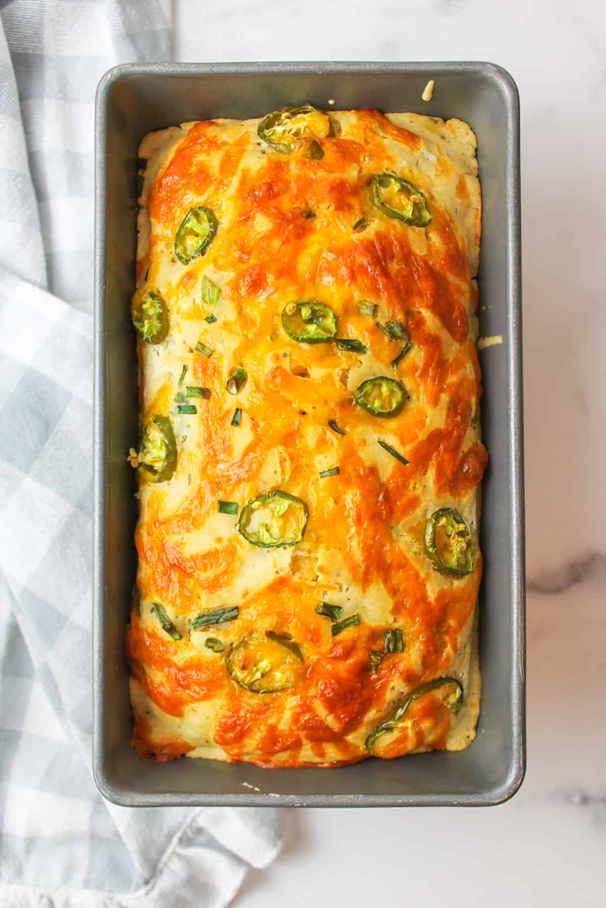 baked jalapeno cheddar beer bread in a bread pan.