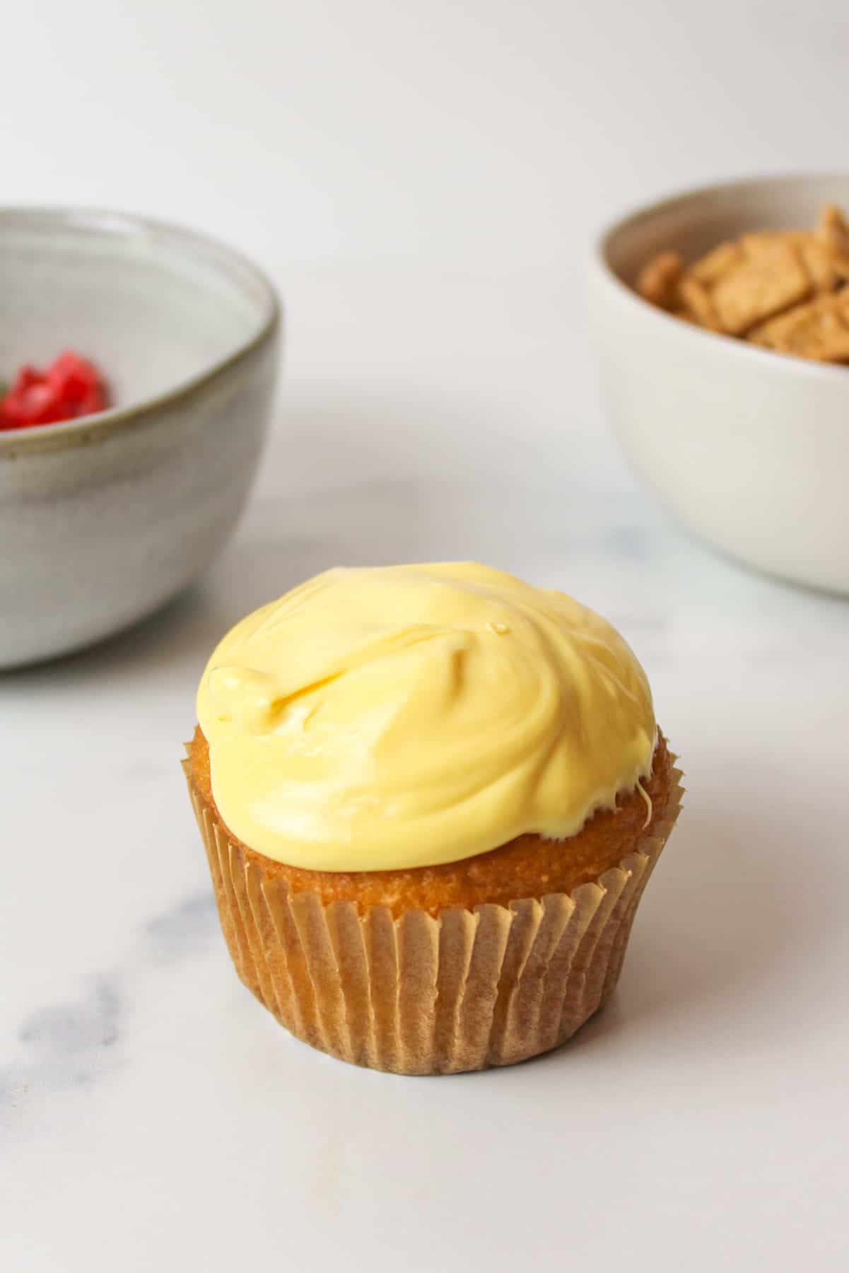 yellow frosting spread over the top of a yellow cupcake