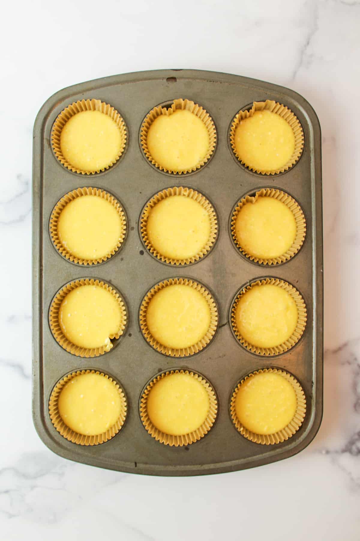 cake batter in mufin pan and paper liners