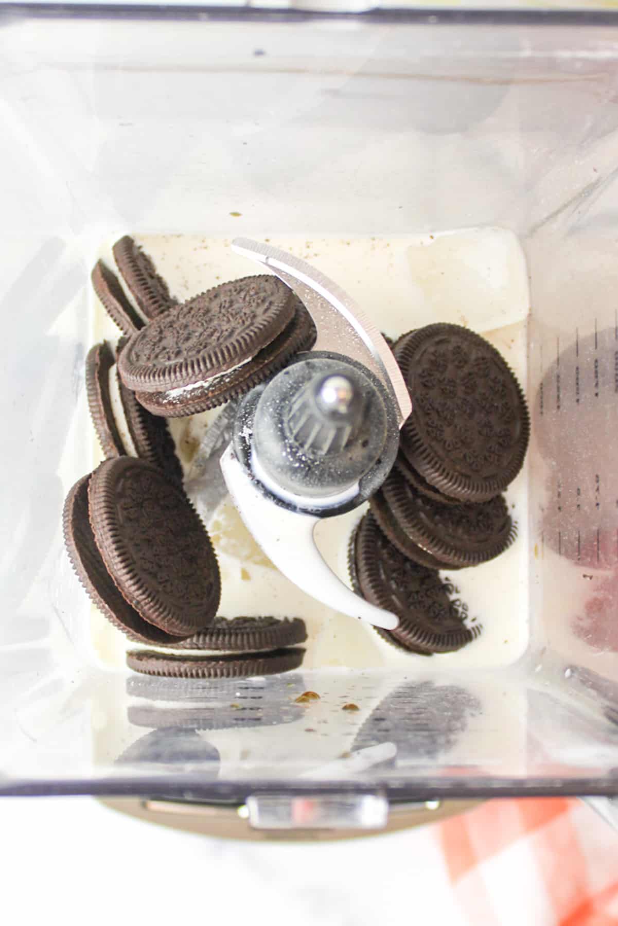 ingredients needed to make oreo milkshake without ice cream inside of a blender.