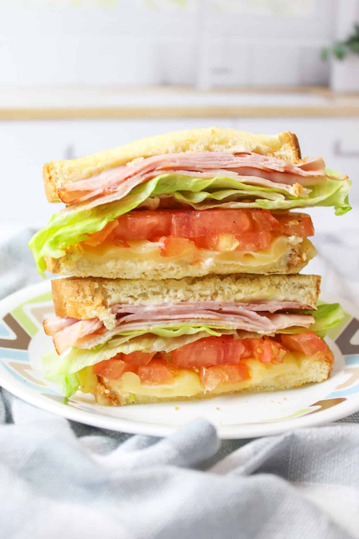 two stacked halves of air fryer club sandwich on a plate.