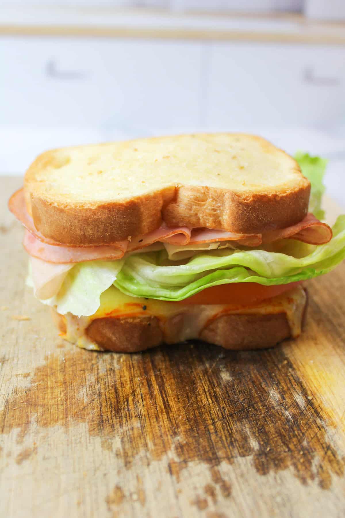 air fried club sandwich assembled on a cutting board.