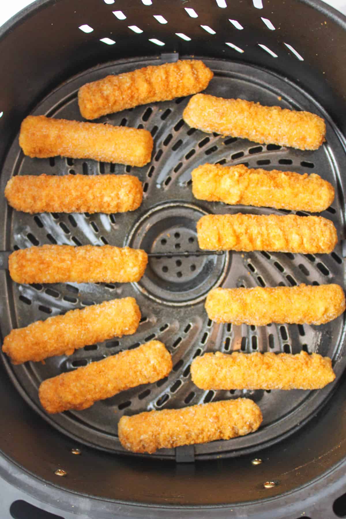 frozen mozarella sticks in an air fryer basket