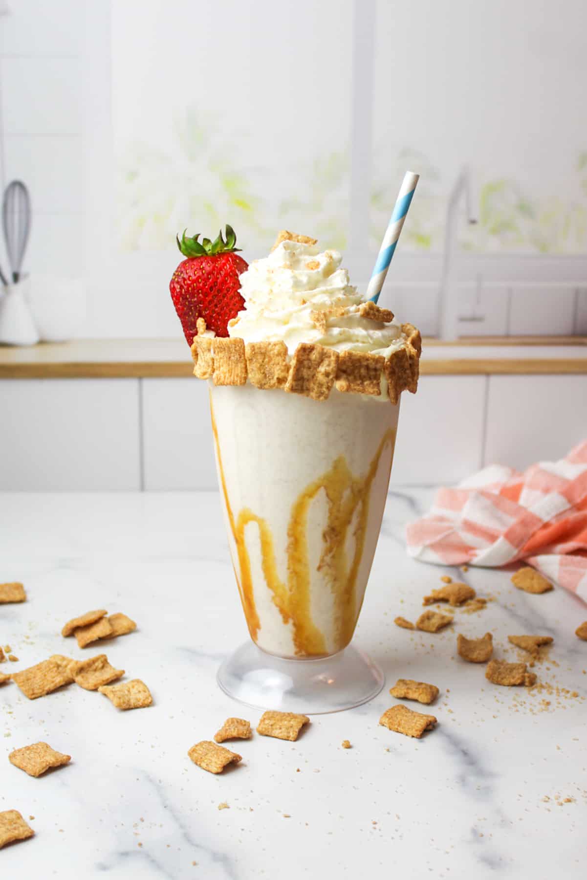 Cinnamon Toast Crunch shake topped with whipped cream and a strawberry.