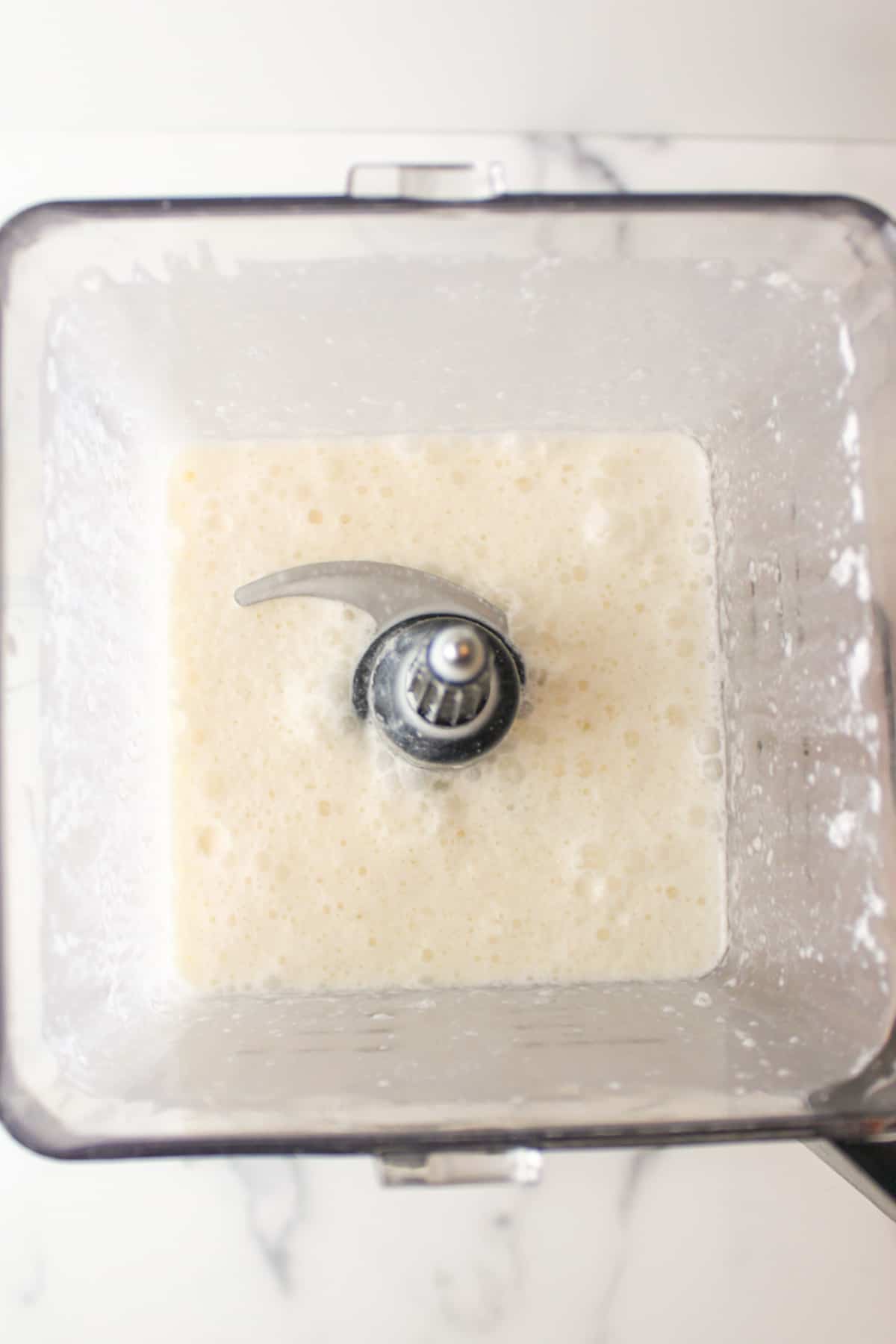inside of a blender showing vanilla milkshake made without ice cream