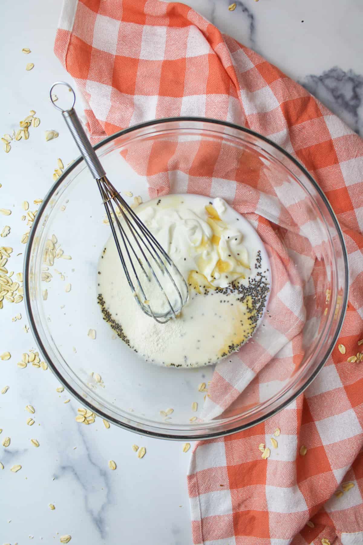 a mixing bowl with a whisk, greek yogurt, vanilla coffee creamer,maple syrup, chia seeds and vanilla inside