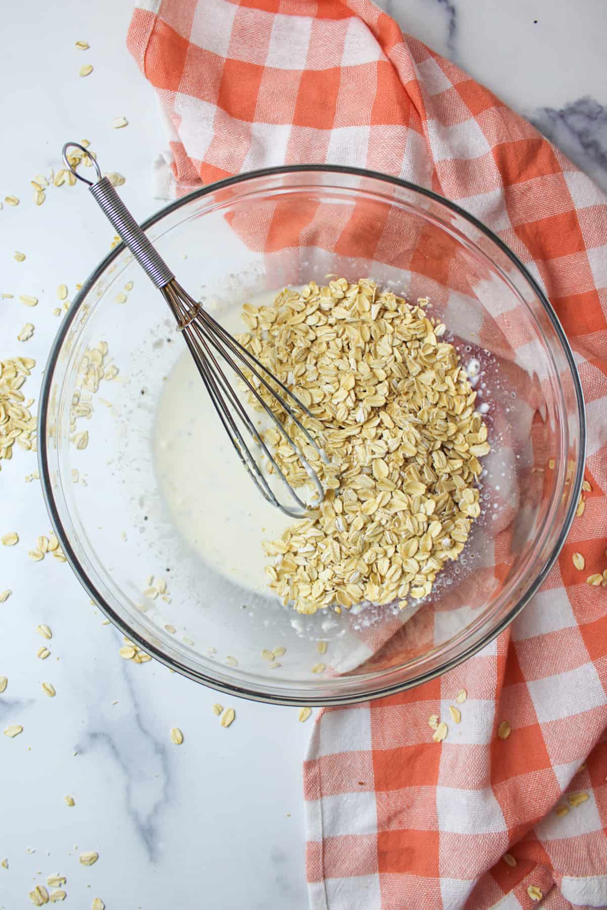 oats on top of wet ingredients in a bowl for overnight oats