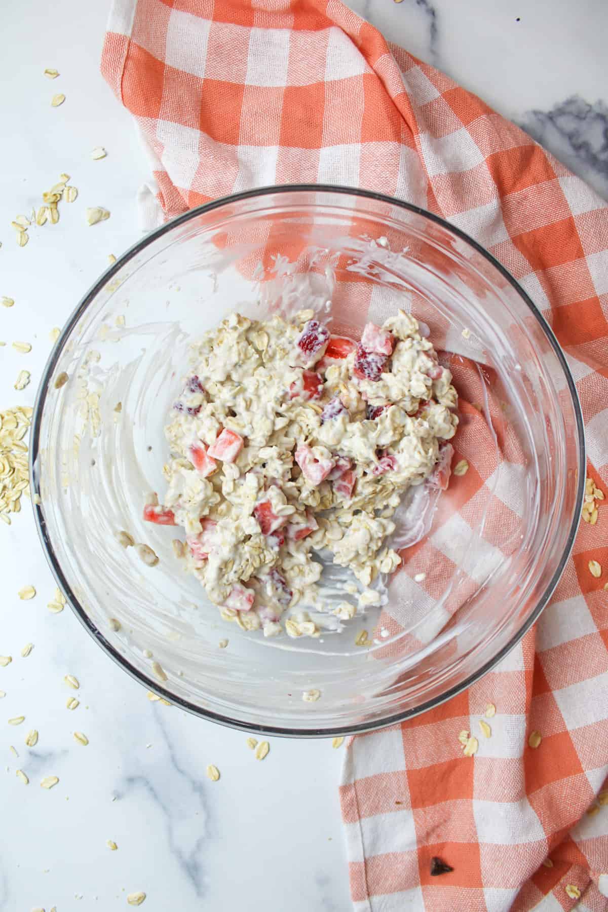 strawberries and cream overnight oats in a glass mixing bowl