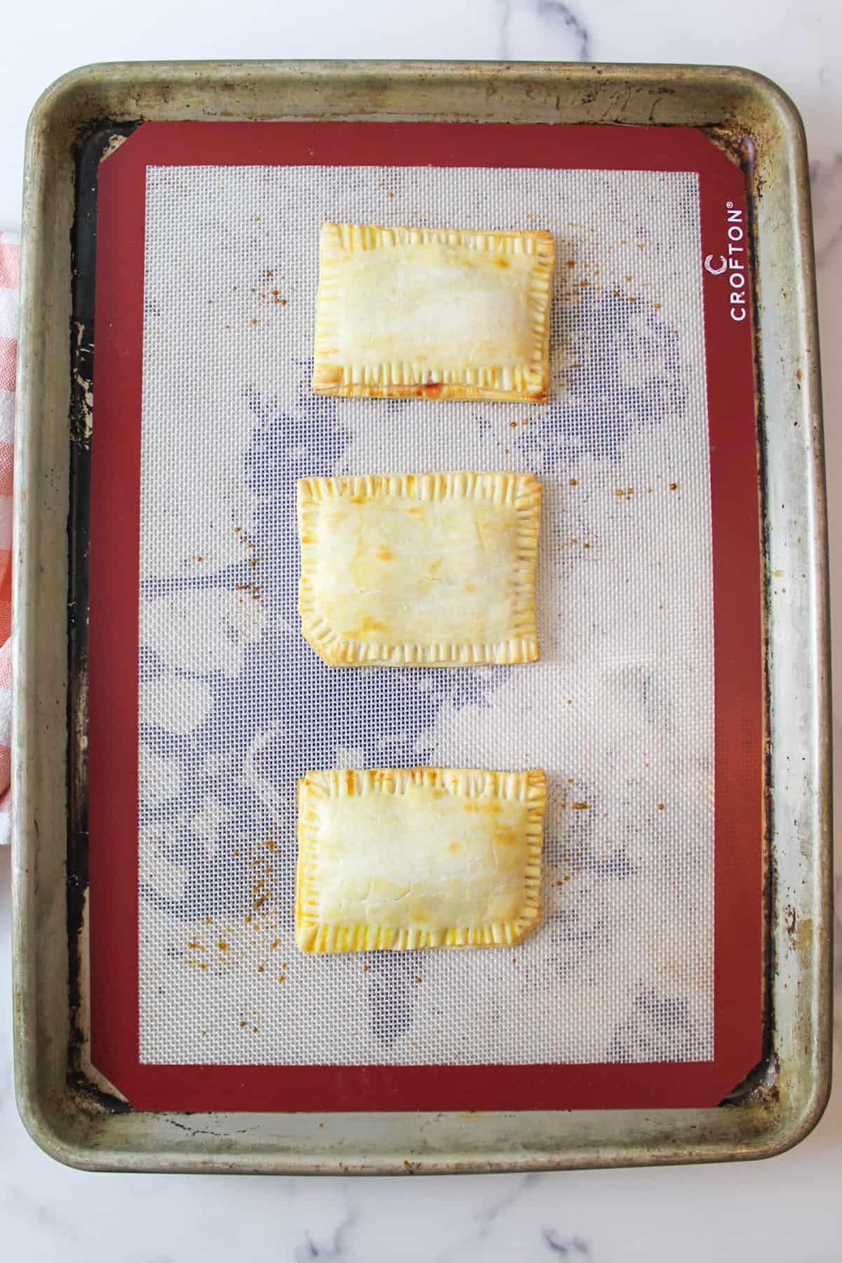 baked Homemade Strawberry Pop Tarts on a silicone lined baking sheet