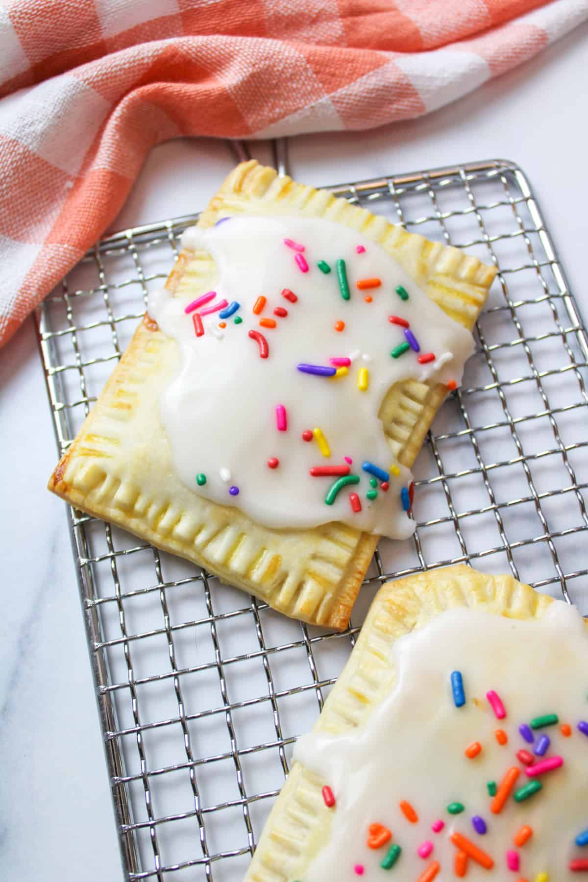 two Homemade Strawberry Pop Tarts on a wire rack