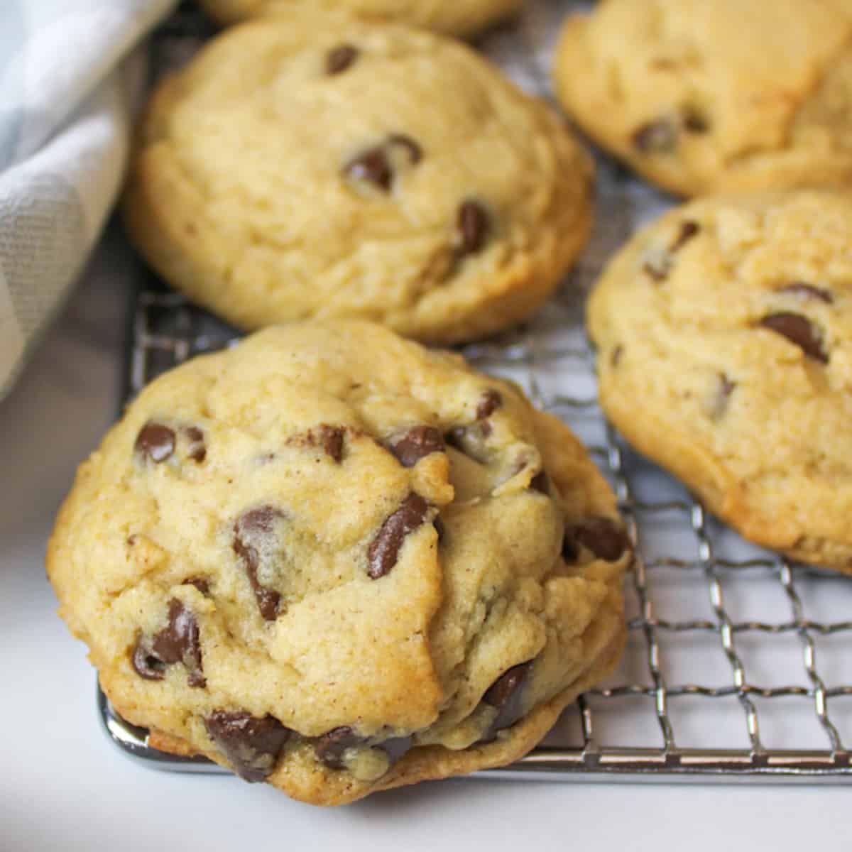 several thick honey chocolate chip cookies on a wire rack.