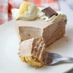 a slice of smores ice cream pie with a fork holding a bite of pie on it.