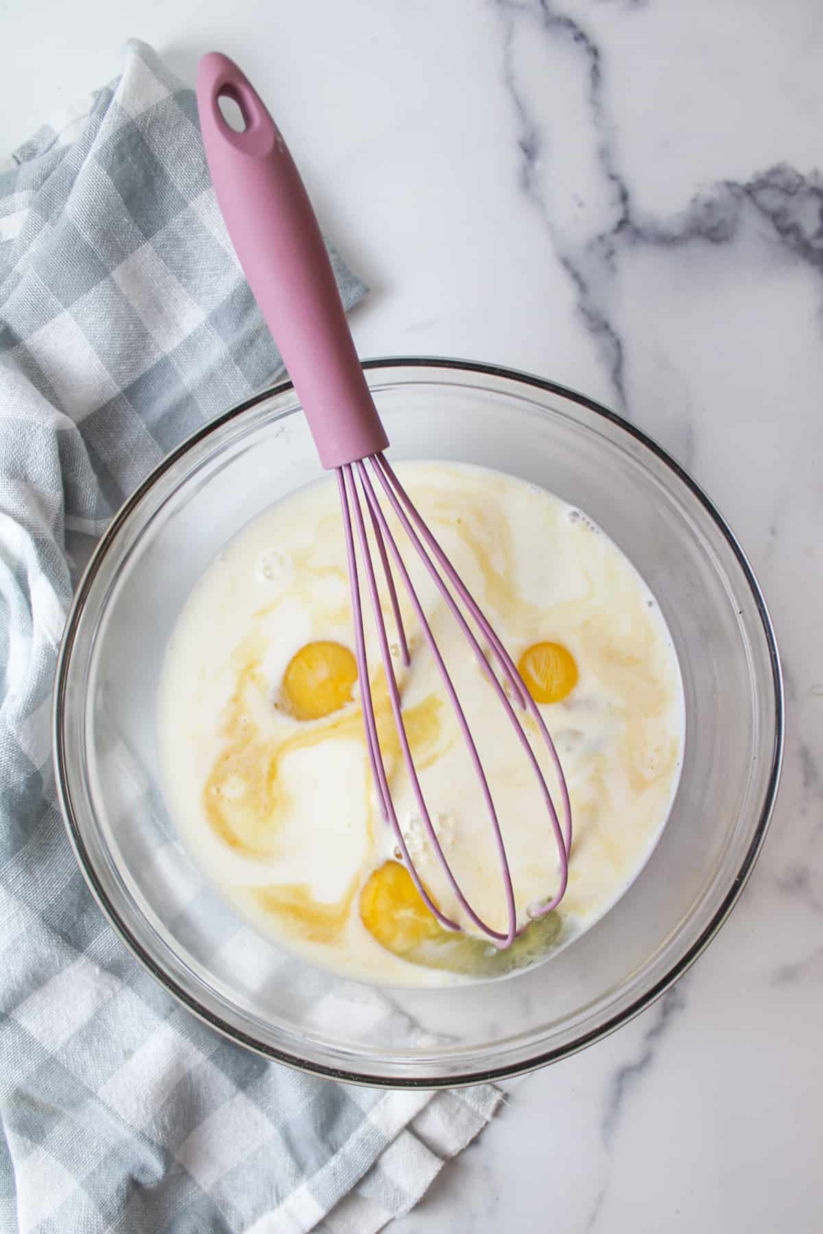 whisking together milk and egg mixture for bread pudding.